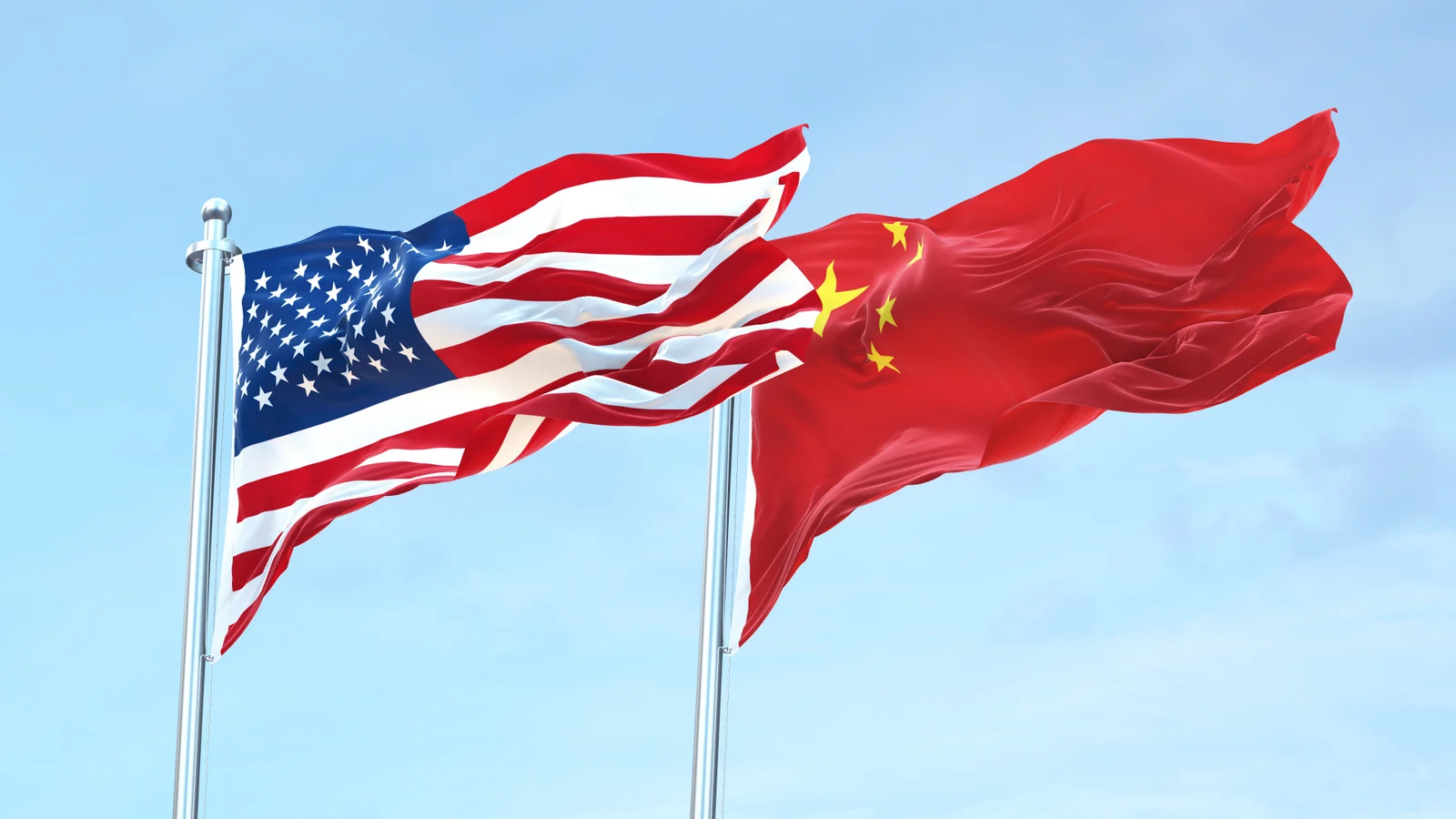 US and Chinese flags flying side by side against a blue sky